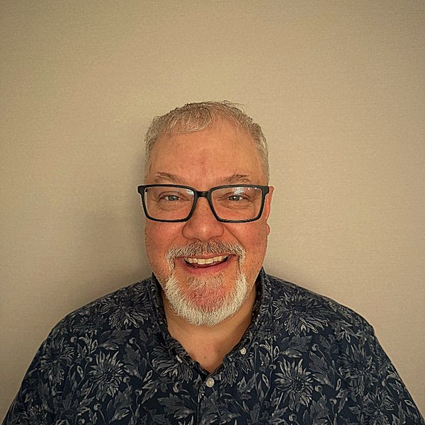 Tom Rankin today — glasses, a grey goatee, and a grin.