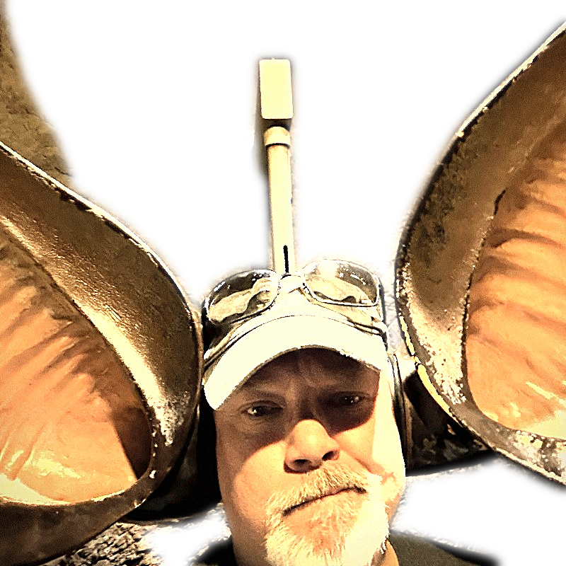 Tom in a tan cap flanked by brass horns